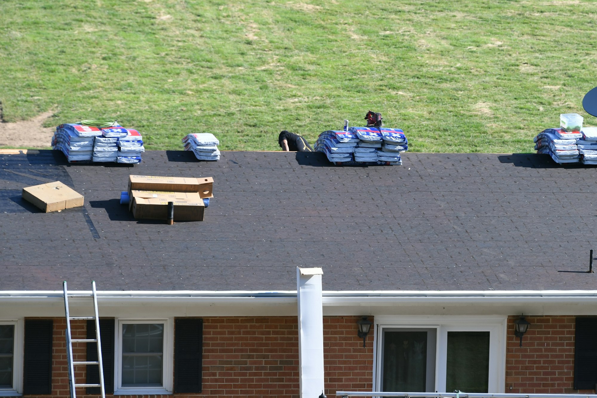 Roofers roofing company repairing a damaged roof with holes, insurance claim storm damage